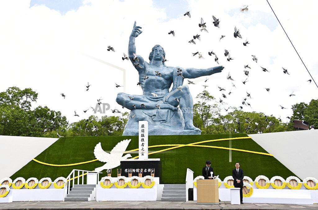 Uncredited Doves fly over the Statue of Peace during a ceremony at Nagasaki Peace Park in Nagasaki, southern Japan Sunday, Aug. 9, 2020, to mark the 75th anniversary of the world's second atomic bomb attack. (Kyodo News via AP)