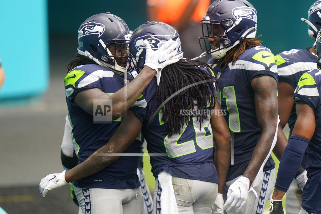 Lynne Sladky Seattle Seahawks cornerback Shaquill Griffin (26) is congratulated by his teammates after he intercepted a pass, during the second half of an NFL football game against the Miami Dolphins, Sunday, Oct. 4, 2020, in Miami Gardens, Fla. (AP Photo/Lynne Sladky)