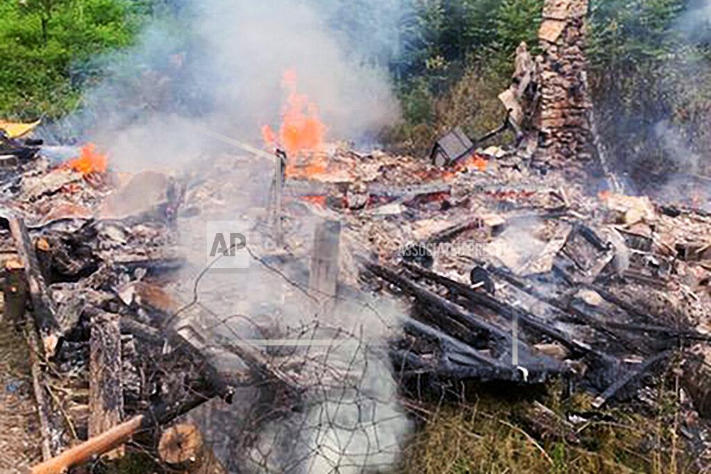 Uncredited In this photo provided by the Canterbury (New Hampshire) Fire Department, smoke rises Wednesday, Aug. 4, 2021, from the burnt remains of a cabin in Canterbury, N.H., inhabited by 81-year-old David Lidstone, who for 27 years has lived in the woods of New Hampshire along the Merrimack River in the once small, solar-paneled cabin. "River Dave," as he's known by boaters and kayakers, has been jailed since July 15 after being accused of squatting for 27 years on the private property. The Canterbury fire chief said there will be an investigation into the fire. (Canterbury Fire Department via AP)