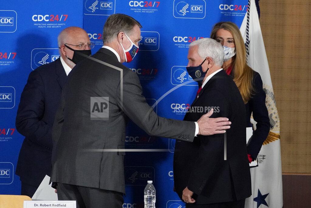 Vice President Mike Pence, right, speaks with Sen. David Perdue, R-Ga., and Sen. Kelly Loeffler, R-Ga, as Centers for Disease Control and Prevention director Dr. Robert Redfield looks on after a meeting on COVID-19 at the CDC Friday, Dec. 4, 2020, in Atlanta. (AP Photo/John Bazemore)