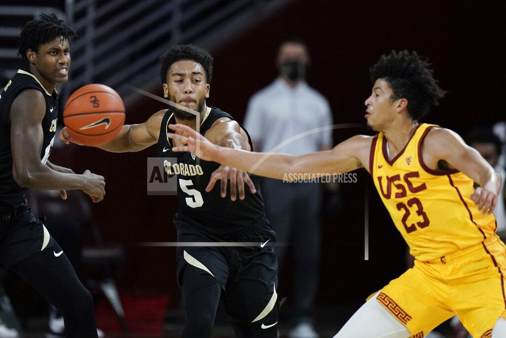 Jae C. Hong Colorado's D'Shawn Schwartz, left, tries to steal the ball from Southern California's Max Agbonkpolo during the first half of an NCAA college basketball game Thursday, Dec. 31, 2020, in Los Angeles. (AP Photo/Jae C. Hong)
