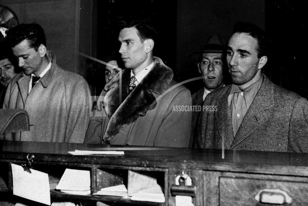 Uncredited FILE - In this March 27, 1951, file photo, three City College of New York basketball players, from left, Norman Mager, Irwin Dambrot and Herb Cohen are booked at New York's Elizabeth Street police station in connection with fixing of three basketball games at Madison Square Garden in 1949 and 1950. Mager and Dambrot last played during 1949-50 season and Cohen was a member of the 1950-51 CCNY squad. “They were kings of the town one day, and the next day they were the bums of the town, really, because of the scandal,” said Dambrot’s nephew, Duquesne coach Keith Dambrot. (AP Photo/File)