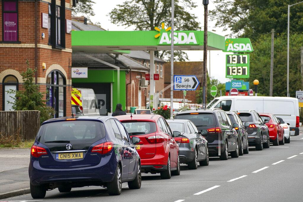 Steve Parsons Cars queue outside a petrol station in Reading, England, Saturday Sept. 25, 2021. The haulage industry says the U.K. is short tens of thousands of truckers, due to a perfect storm of factors including the coronavirus pandemic, an aging workforce and an exodus of European Union workers following Britain’s departure from the bloc. BP and Esso shut a handful of their gas stations this week, and motorists have formed long lines as they try to fill up in case of further disruption. Steve Parsons/PA via AP)