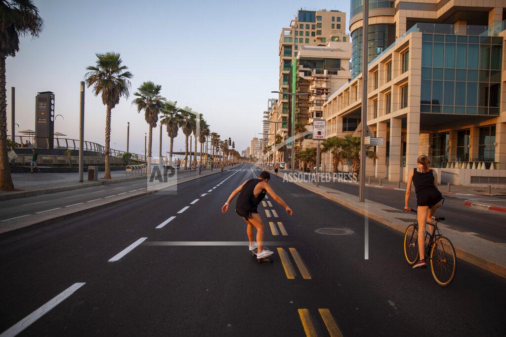 Oded Balilty People ride on a car-free road during Yom Kippur, the holiest day in the Jewish year, during a nationwide three-week lockdown to curb the spread of the coronavirus, in Tel Aviv, Israel, Sunday, Sept. 27, 2020. (AP Photo/Oded Balilty)