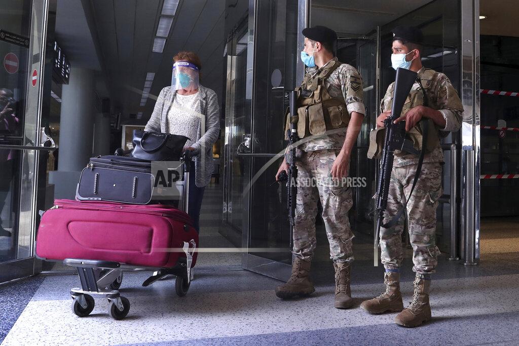 Bilal Hussein Lebanese soldiers stand guard as a woman leaves the Rafik Hariri International Airport in Beirut, Lebanon, Wednesday, July 1, 2020. Beirut's airport is partially reopening after a three-month shutdown and Lebanon's cash-strapped government is hoping that thousands of Lebanese expatriates will return for the summer, injecting dollars into the country's sinking economy. (AP Photo/Bilal Hussein)