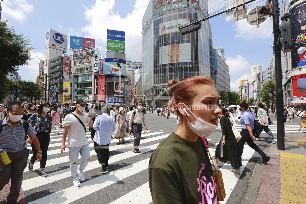 Koji Sasahara People wearing face masks to protect against the spread of the coronavirus walk on a street in Tokyo Wednesday, July 28, 2021. Tokyo Gov. Yuriko Koike on Wednesday urged younger people to cooperate with measures to bring down the high number of infections and get vaccinated, saying their activities are key to slowing the surge during the Olympics. On Tuesday, the Japanese capital reported 2,848 new cases, exceeding its previous record in January. (AP Photo/Koji Sasahara)