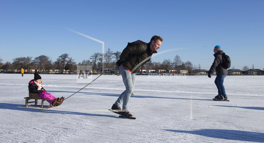 Peter Dejong People skate on Nannewiid Lake in Oudehaske, Netherlands, Friday, Feb. 12, 2021. With many lakes and canals in the Netherlands frozen over, Dutch skating fans flocked to the ice Friday, causing a headache for authorities trying to enforce social distancing measures to stop the spread of the coronavirus. (AP Photo/Peter Dejong)