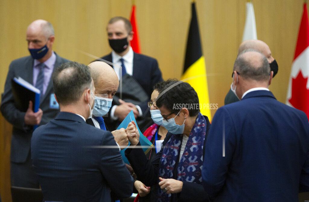 Virginia Mayo French Foreign Minister Jean-Yves Le Drian, center left, greets Spanish Foreign Minister Arancha Gonzalez Laya, center right, with a fist bump during a meeting of NATO foreign ministers at NATO headquarters in Brussels on Tuesday, March 23, 2021. (AP Photo/Virginia Mayo, Pool)