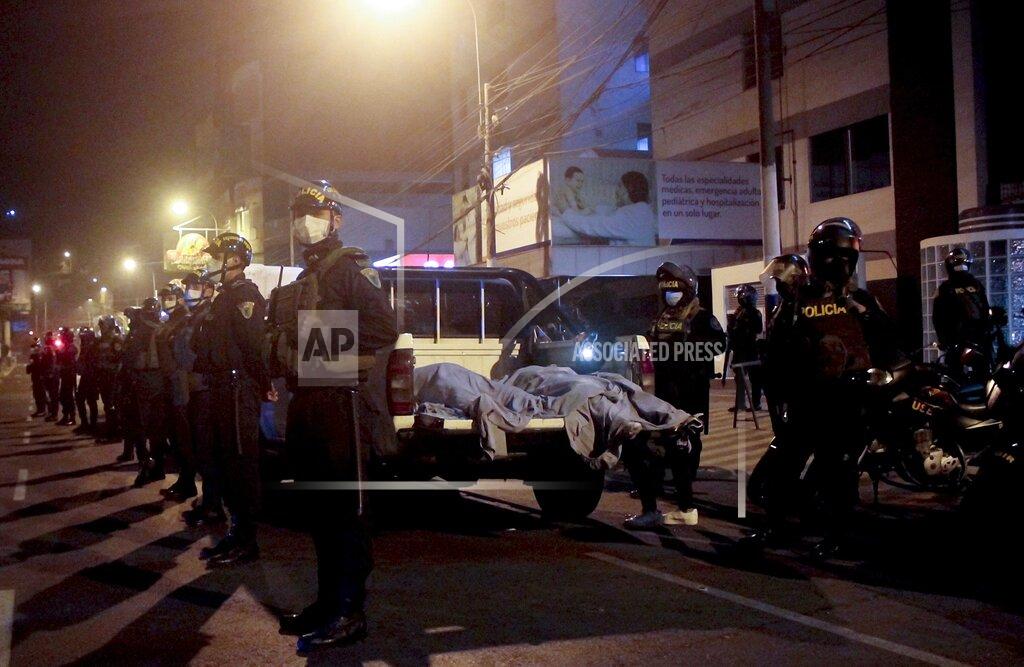 Diego Vertiz Police officers stand guard near two bodies outside of a disco in Lima, Peru, Sunday, Aug. 23, 2020. Officials said over a dozen people died in a stampede at a disco in Peru after a police raid to enforce the country's lockdown during the coronavirus pandemic. (AP Photo/Diego Vertiz)