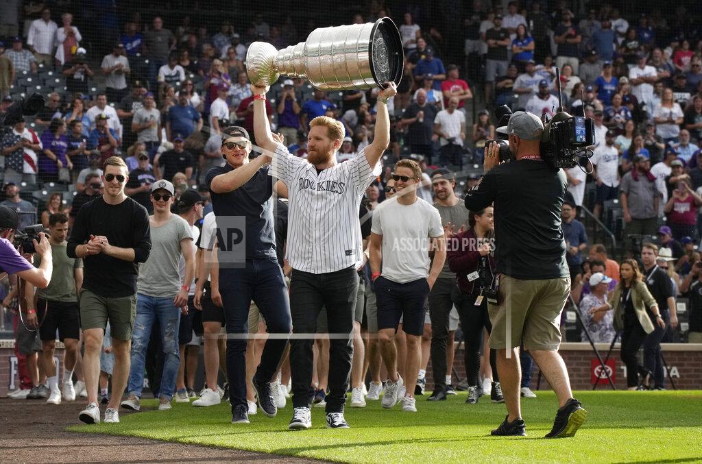 David Zalubowski Colorado Avalanche captain Gabriel Landeskog holds up the Stanley Cup as the NHL hockey team was honored by the Colorado Rockies before the baseball team's game against the Los Angeles Dodgers on Wednesday, June 29, 2022, in Denver. (AP Photo/David Zalubowski)