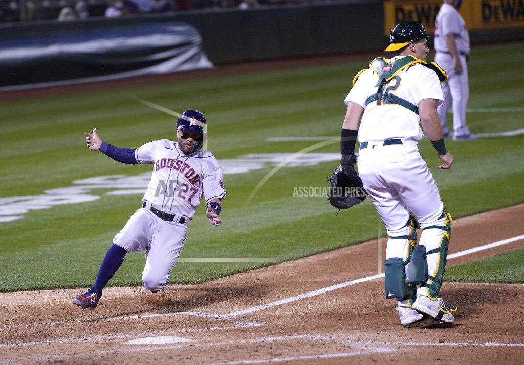 Tony Avelar Houston Astros' Jose Altuve (27) slides into home plate past Oakland Athletics catcher Sean Murphy (12) to score a run during the fourth inning of an opening day baseball game Oakland, Calif., Thursday, April 1, 2021. (AP Photo/Tony Avelar)