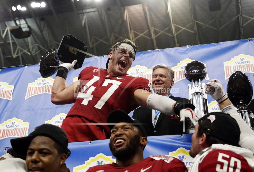 Eric Gay Washington State linebacker Peyton Pelluer (47) holds his Defensive Player of the Game trophy as he celebrates the team's 28-26 win over Iowa State in the Alamo Bowl NCAA college football game, Friday, Dec. 28, 2018, in San Antonio. (AP Photo/Eric Gay)