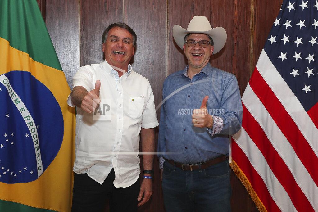 In this photo distributed by Brazil's presidential press office, Brazilian President Jair Bolsonaro, left, and U.S. Ambassador Todd Chapman pose for a photo during an event to mark U.S. Independence Day at the ambassador's residence in Brasilia, Brazil, Saturday, July 4, 2020. (Isac Nobrega/Brazil's presidential press office via AP)