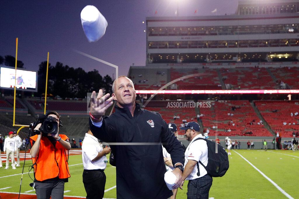 Karl B Deblaker North Carolina State coach Dave Doeren tosses T-shirts to the student section before the team's NCAA college football game against Syracuse in Raleigh, N.C., Thursday, Oct. 10, 2019. (AP Photo/Karl B DeBlaker)