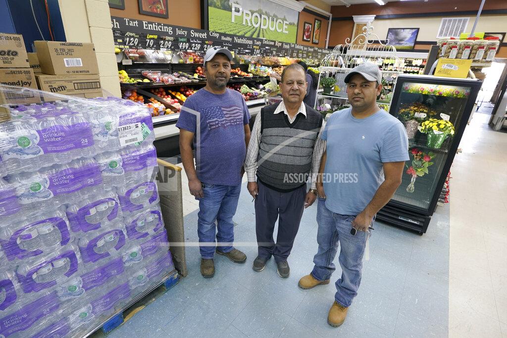 Ted S. Warren Singh Maan, center, poses for a photo with his sons CJ Maan, left, and Ricky Maan, right, Monday, Sept. 27, 2021, in the grocery store they own in Chester, Mont., near the scene where an Amtrak train derailed Saturday, killing three people and injuring others. When the crash happened, the family rushed to the scene with first-aid and food supplies taken right from the shelves of their store. (AP Photo/Ted S. Warren)