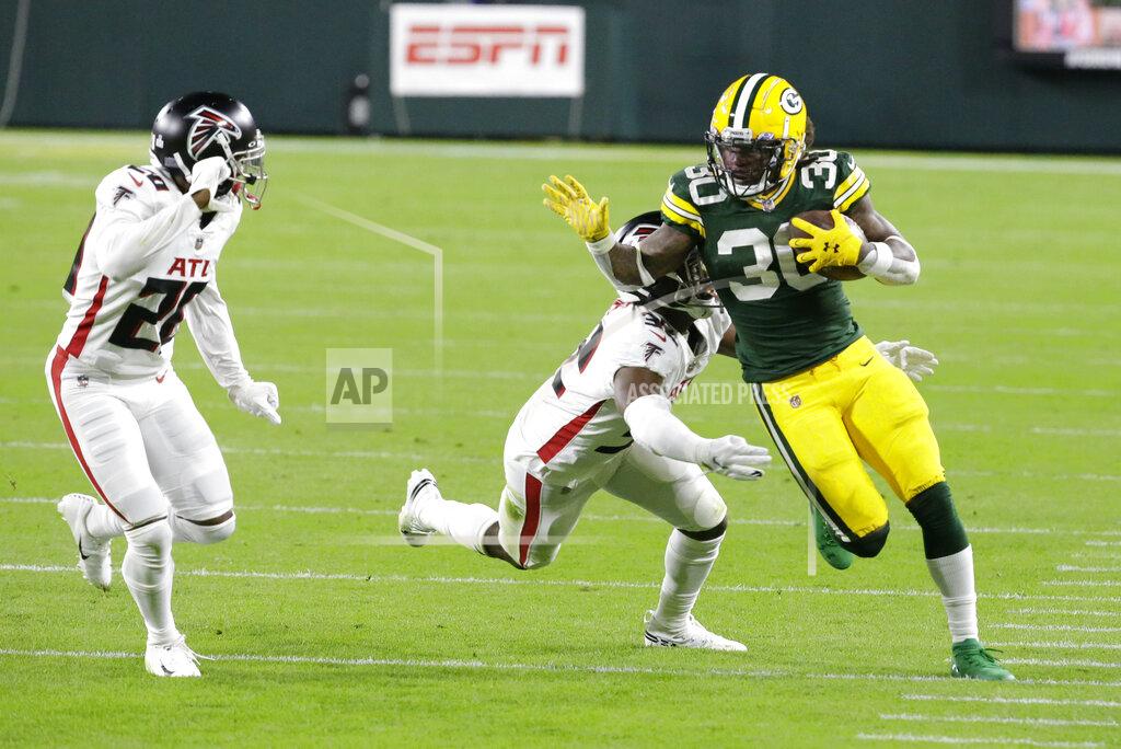 Mike Roemer Green Bay Packers' Jamaal Williams (30) is tackled by Atlanta Falcons' Jaylinn Hawkins (32) and Kendall Sheffield (20) nduring the first half of an NFL football game, Monday, Oct. 5, 2020, in Green Bay, Wis. (AP Photo/Mike Roemer)