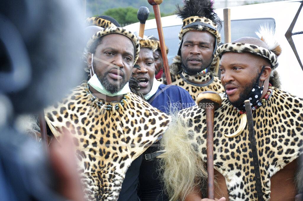 Prince Misuzulu Zulu, left, flanked by fellow warriors in traditional dress at the KwaKhangelamankengane Royal Palace, during a ceremony, in Nongoma, Friday May 7, 2021. A new Zulu king in South Africa has been named amid scenes of chaos as other members of the royal family questioned Prince Misuzulu Zulu’s claim to the title. He was suddenly whisked away from the public announcement at a palace by bodyguards. The controversy over the next king has arisen after the death in March of King Goodwill Zwelithini, who had reigned since 1968. Zwelithini apparently named one of his six wives, Queen Mantfombi Shiyiwe Dlamini Zulu, as the “regent of the Zulu kingdom” in his will. But her death just over a week ago after holding the title for only a month has thrown the royal succession into turmoil. (AP Photo)