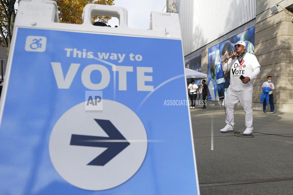 Ted S. Warren Paul Patu performs hip-hop music with the theme of "Drop The Vote," Monday, Nov. 2, 2020, outside a voting center in Seattle where people can drop off ballots or get help registering to vote or obtaining their ballots. Patu is the executive director of the Seattle-based organization Urban Family, who came up with the Drop The Vote campaign to encourage and educate voters from underserved communities. (AP Photo/Ted S. Warren)