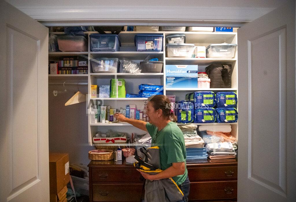 Sophia Germer Sue Roesky opens her 31-year-old daughter, Lauren's, closet to show everything they would need to evacuate if they were going to be gone for more than a few days, at their home in Metairie, La., Friday, Sept. 17, 2021. (Sophia Germer/The Times-Picayune/The New Orleans Advocate via AP)