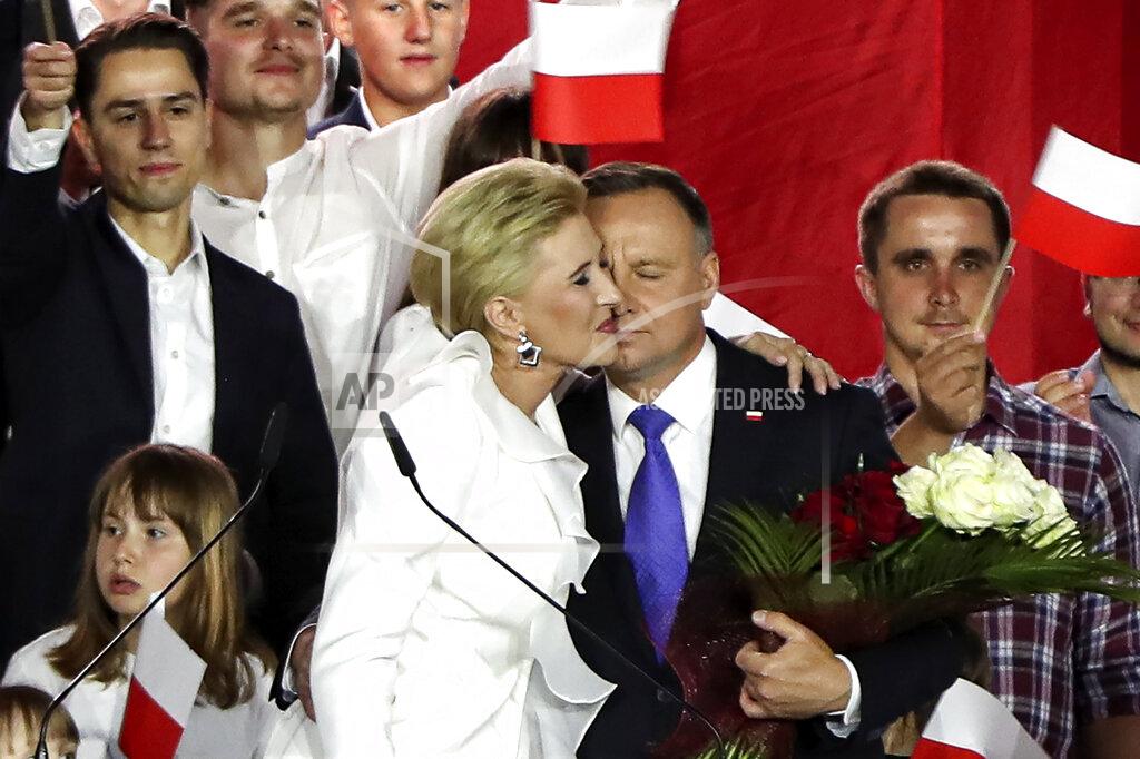 Czarek Sokolowski Incumbent President Andrzej Duda is hugged by his wife Agata Kornhauser-Duda in Pultusk, Poland, Sunday, July 12, 2020. An exit poll in Poland's presidential runoff election shows a tight race that is too close to call between the conservative incumbent, Andrzej Duda, and the liberal Warsaw mayor, Rafal Trzaskowski.(AP Photo/Czarek Sokolowski)