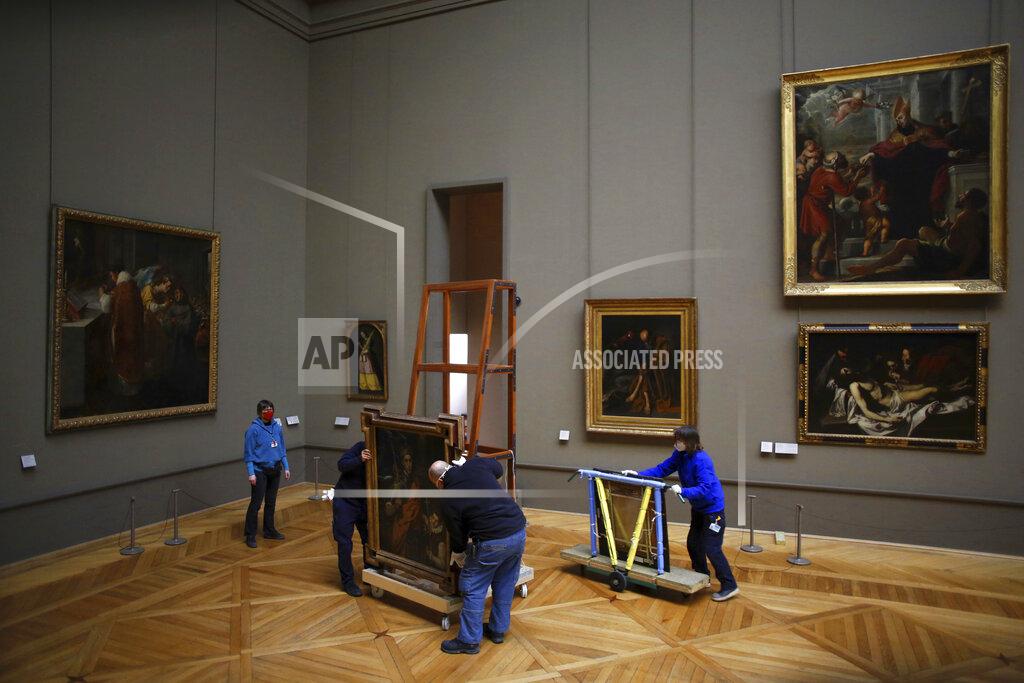 Thibault Camus Workers at the Louvre museum handle a painting called Saint Louis, King of France, and his Page by Spanish painter El Greco, as it returns from an exhibition at the Chicago Institute, in the Louvre museum, in Paris, Tuesday, Feb. 9, 2021. (AP Photo/Thibault Camus)