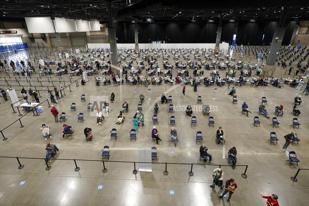 People sit in chairs in an observation area, Saturday, March 13, 2021, after getting shots of the Pfizer COVID-19 vaccine on the first day of operations at a mass vaccination site at the Lumen Field Events Center in Seattle, which adjoins the field where the NFL football Seattle Seahawks and the MLS soccer Seattle Sounders play their games. The site, which is the largest civilian-run vaccination site in the country, will operate only a few days a week until city and county officials can get more doses of the vaccine. (AP Photo/Ted S. Warren)