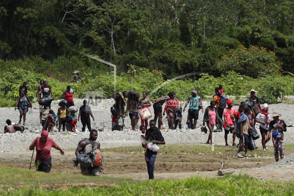 Arnulfo Franco Migrants cross the Tuquesa River after a trip on foot through the jungle to Bajo Chiquito, Darien province, Panama, Wednesday, Feb. 10, 2021. Panama reopened its border in late January and ever since groups have been walking out of the dense Darien jungle that divides Panama and Colombia. (AP Photo/Arnulfo Franco)