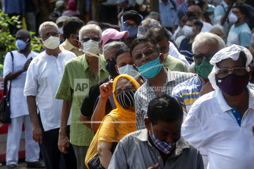 Rafiq Maqbool FILE - In this April 26, 2021, file photo, people line up for the coronavirus vaccine in Mumbai, India. As deaths mount and a vaccine rollout falters badly, Prime Minister Narendra Modi has pushed much of the responsibility for fighting the outbreak onto unprepared and poorly equipped state governments. The crisis has badly dented Modi’s carefully cultivated image as an able technocrat. (AP Photo/Rafiq Maqbool, File)