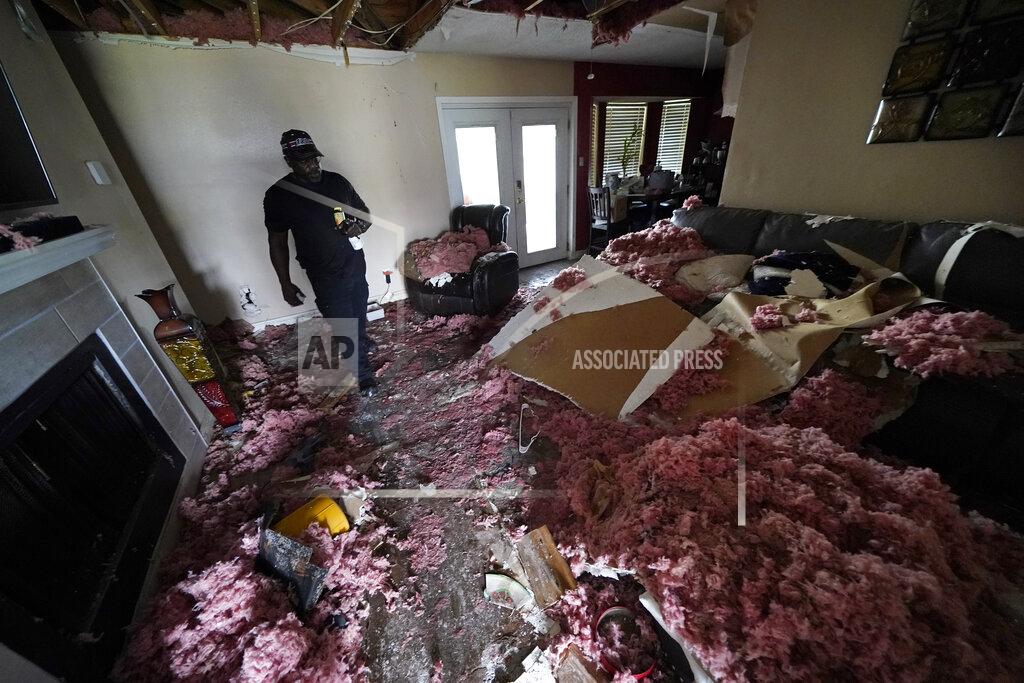 Gerald Herbert Michael Lathers walks past the collapsed ceiling in his flooded home in the aftermath of Hurricane Ida in LaPlace, La., Tuesday, Sept. 7, 2021. (AP Photo/Gerald Herbert)