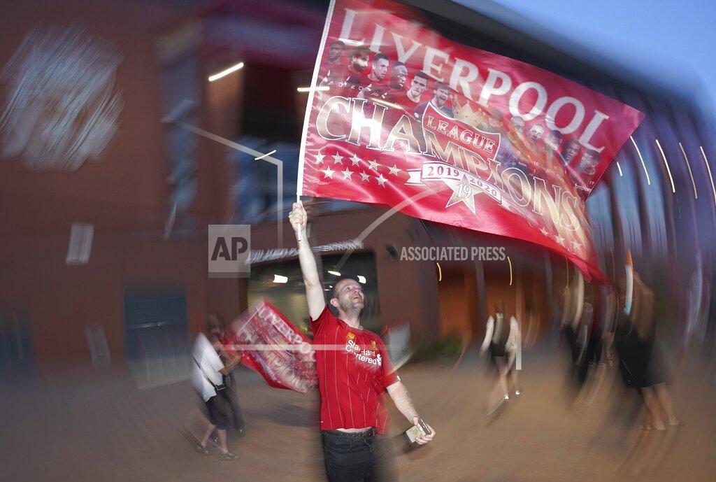 Jon Super A Liverpool supporter celebrates outside Anfield Stadium in Liverpool, England, Thursday, June 25, 2020 after hearing Chelsea had scored in the English Premier League soccer match between Chelsea and Manchester City. Liverpool will be crowned Premier League champions if Manchester City fail to beat Chelsea. (AP Photo/Jon Super)