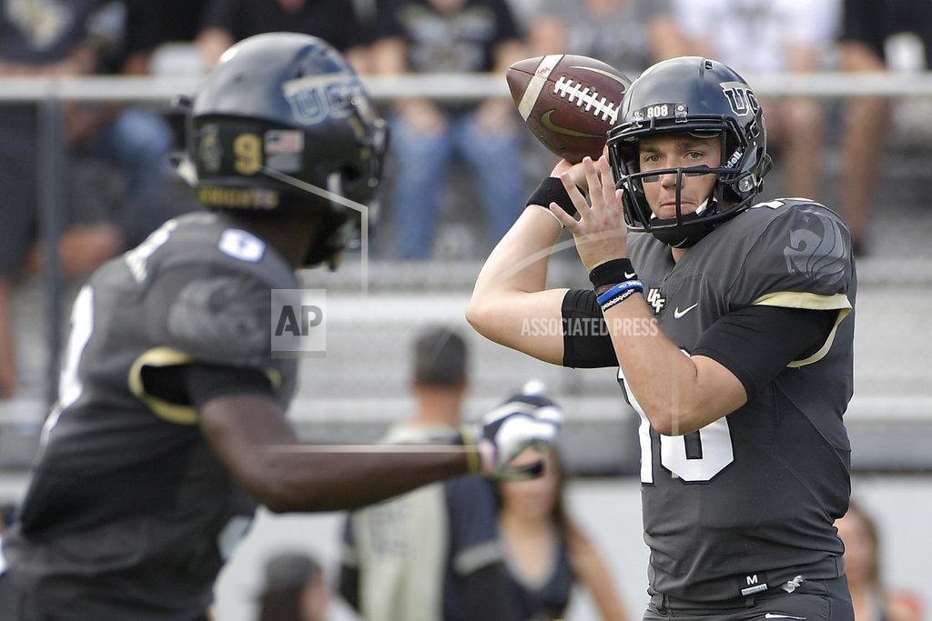 FILE - In this Nov. 10, 2018, file photo, Central Florida quarterback McKenzie Milton, right, throws a pass to running back Adrian Killins Jr. (9) during the first half of an NCAA college football game against Navy in Orlando, Fla. No. 8 UCF isn't content with having the nation's longest winning streak. The Knights want more. A lot more. The defending American Athletic Conference champions can complete a second consecutive undefeated regular season by beating intrastate rival South Florida on Friday, Nov. 23. “From where this program's come, it's just getting started,” Milton said. “I think we're just scratching the surface and UCF is going to be good for a very, very long time.” (AP Photo/Phelan M. Ebenhack, File)