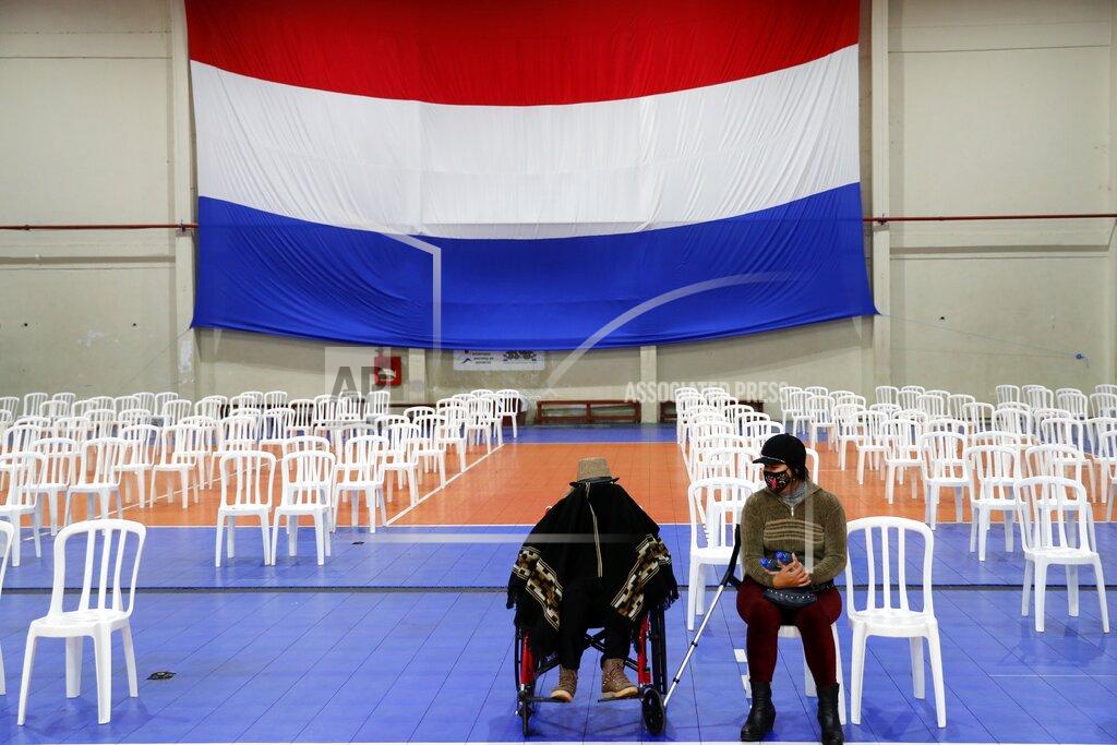 Jorge Saenz An elderly woman, who is accompanied by her granddaughter, waits to be inoculated with the AstraZeneca COVID-19 vaccine at a sports stadium in Asuncion, Paraguay, Thursday, May 6, 2021. (AP Photo/Jorge Saenz)