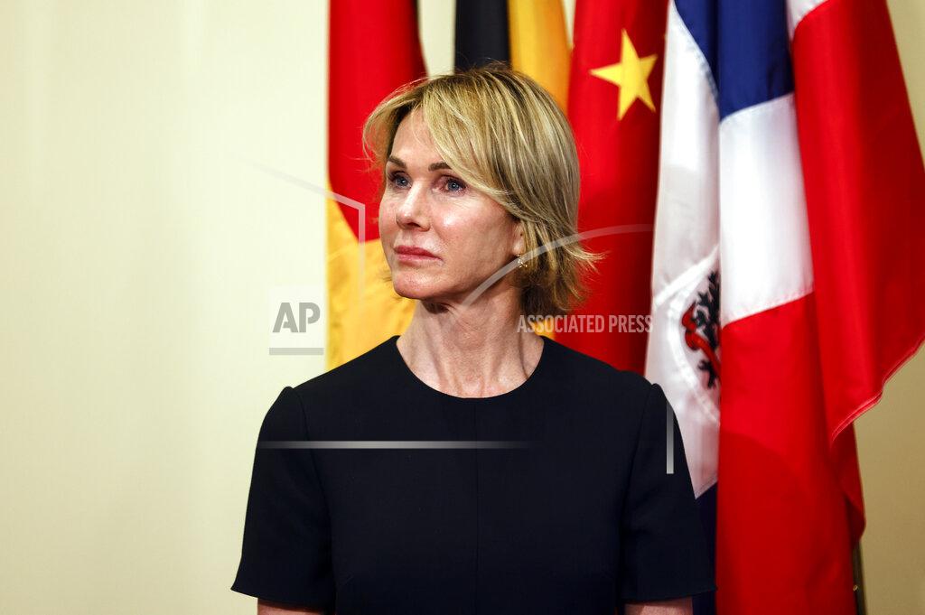 U.S. Ambassador to the United Nations Kelly Craft listens as Secretary of State Mike Pompeo speaks to reporters following a meeting with members of the U.N. Security Council, Thursday, Aug. 20, 2020, at the United Nations. The Trump administration has formally notified the United Nations of its demand for all U.N. sanctions on Iran to be restored, citing significant Iranian violations of the 2015 nuclear deal. (Mike Segar/Pool via AP)