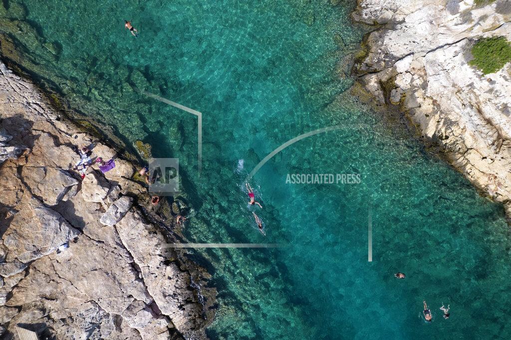 Yorgos Karahalis People swim in the sea at Vouliagmeni suburb, southwest of Athens, on Thursday, July 29, 2021. One of the most severe heat waves recorded since 1980s scorched southeast Europe on Thursday, sending residents flocking to the coast, public fountains and air-conditioned locations to find some relief, with temperatures rose above 40 C (104 F) in parts of Greece and across much of the region. (AP Photo/Yorgos Karahalis)