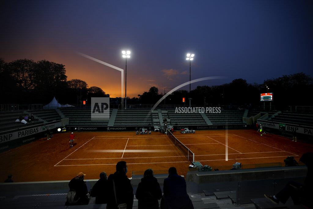 Alessandra Tarantino The sun sets over court 14 as Italy's Jannik Sinner, right, and Argentina's Federico Coria, left, play their third round match of the French Open tennis tournament at the Roland Garros stadium in Paris, France, Friday, Oct. 2, 2020. (AP Photo/Alessandra Tarantino)