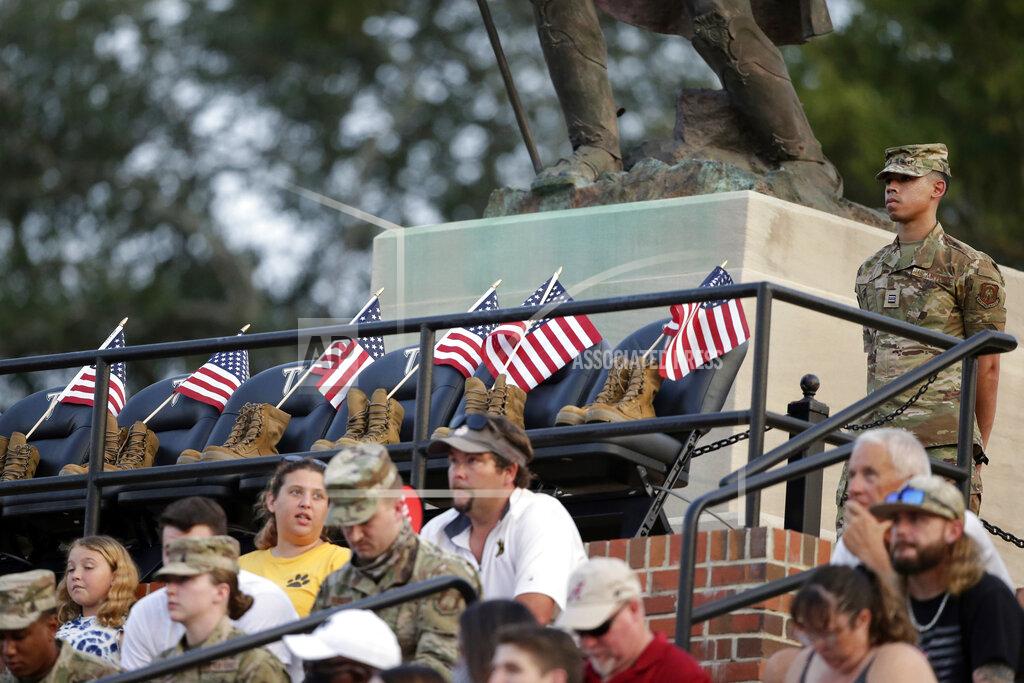 Butch Dill A Troy Army ROTC member stands guard over seats honoring the 13 soldiers killed recently in Afghanistan, during the first half of an NCAA college football game between Troy and Liberty, Saturday, Sept. 11, 2021, in Troy, Ala. (AP Photo/Butch Dill)