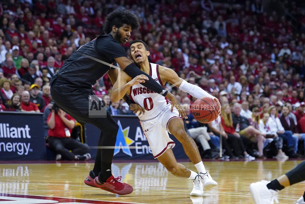Andy Manis Wisconsin's D'Mitrik Trice (0) is fouled by Rutgers' Myles Johnson (15) during the second half of an NCAA college basketball game Sunday, Feb. 23, 2020, in Madison, Wis. Wisconsin won 79-71. (AP Photo/Andy Manis)
