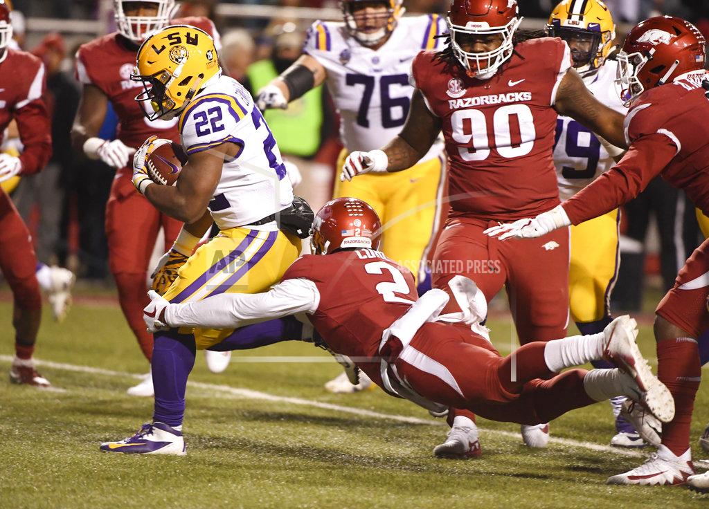 Michael Woods LSU running back Clyde Edwards-Helaire slips past Arkansas defender Kamren Curl to score a touchdown during the second half of an NCAA college football game, Saturday, Nov. 10, 2018, in Fayetteville, Ark. LSU won, 24-17. (AP Photo/Michael Woods)