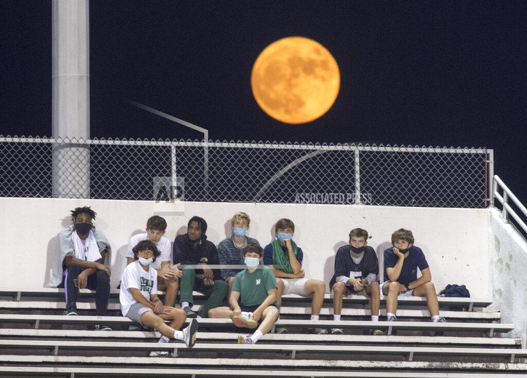 Chris Granger A harvest moon rises with Yenni Stadium in the foreground, while Newman students watch their school play East Jefferson in a high school football game in Metairie, La., during the coronavirus pandemic, Thursday, Oct. 1, 2020. (Chris Granger/The Times-Picayune/The New Orleans Advocate via AP)