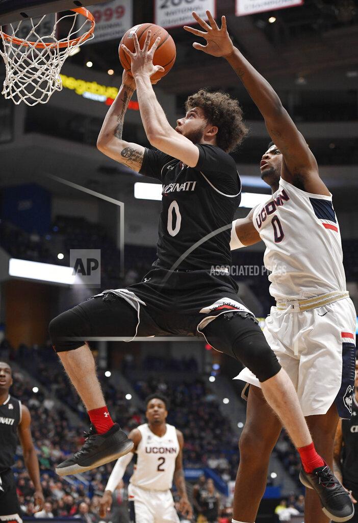 Jessica Hill Cincinnati's Logan Johnson makes a basket as Connecticut's Eric Cobb (0) defends during the first half of an NCAA college basketball game, Sunday, Feb. 24, 2019, in Hartford, Conn. (AP Photo/Jessica Hill)