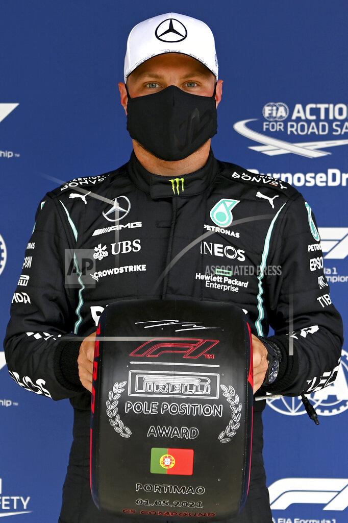 Gabriel Buoys Mercedes driver Valtteri Bottas of Finland poses after he clocked the fastest time during the qualifying session ahead of the Portugal Formula One Grand Prix at the Algarve International Circuit near Portimao, Portugal, Saturday, May 1, 2021. The Portugal Grand Prix will be held on Sunday. (Gabriel Buoys/Pool via AP)