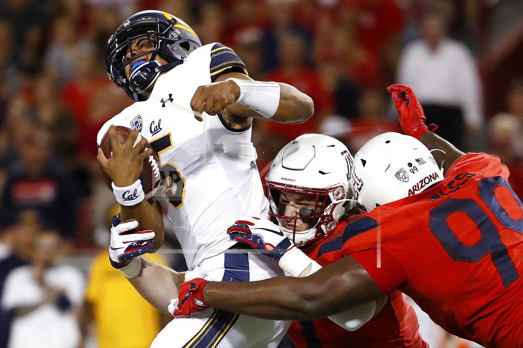 Chris Coduto Arizona linebacker Colin Schooler (7) and defensive tackle Dereck Boles (99) tackle California quarterback Brandon McIlwain (5) during the first half of an NCAA college football game Saturday, Oct. 6, 2018, in Tucson, Ariz. (AP Photo/Chris Coduto)