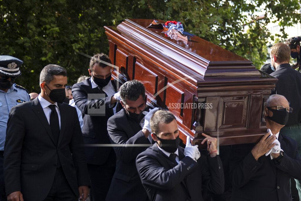 Petros Giannakouris Pallbearers carry the coffin of late Greek composer, Mikis Theodorakis in Athens on Monday Sept. 6, 2021. Hundreds of people have gathered outside Athens Cathedral where Greek composer and politician Mikis Theodorakis is to lie in state in a chapel of the cathedral for three days ahead of his burial on the southern island of Crete.(AP Photo/Petros Giannakouris)