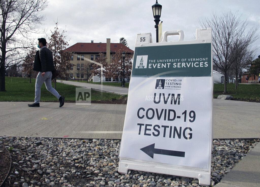 Lisa Rathke FILE - In this Nov. 12, 2020, file photo, a University of Vermont student walks toward a tent leading to a COVID-testing site on campus in Burlington, Vt. Colleges throughout the U.S. are assuring students that this coming fall will bring a return to in-person classes, intramural sports and mostly full dormitories. But those promises come with asterisks. (AP Photo/Lisa Rathke, File)
