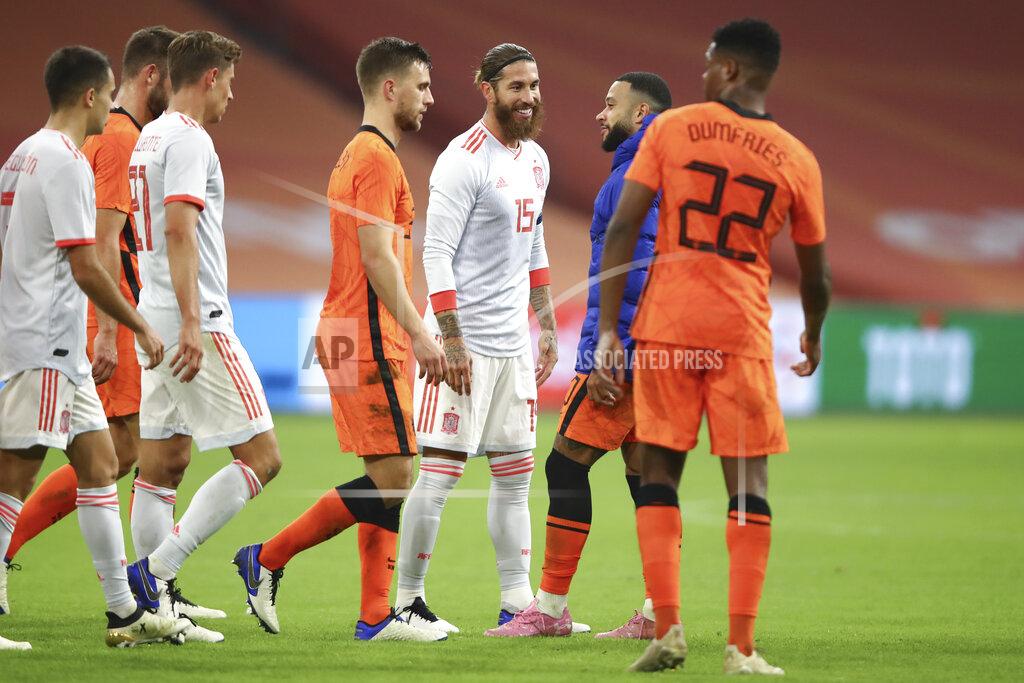 Dean Mouhtaropoulos Spain's Sergio Ramos, center, talks to Netherlands' Memphis Depay after the international friendly soccer match between The Netherlands and Spain at the Johan Cruyff ArenA in Amsterdam, Netherlands, Wednesday, Nov. 11, 2020. Ramos came on as an 85th-minute substitute for his 176th international, drawing level with former Italy goalkeeper Gianluigi Buffon as the European with the most caps. The world record is Ahmed Hassan's 184 for Egypt. (Dean Mouhtaropoulos/Pool via AP)