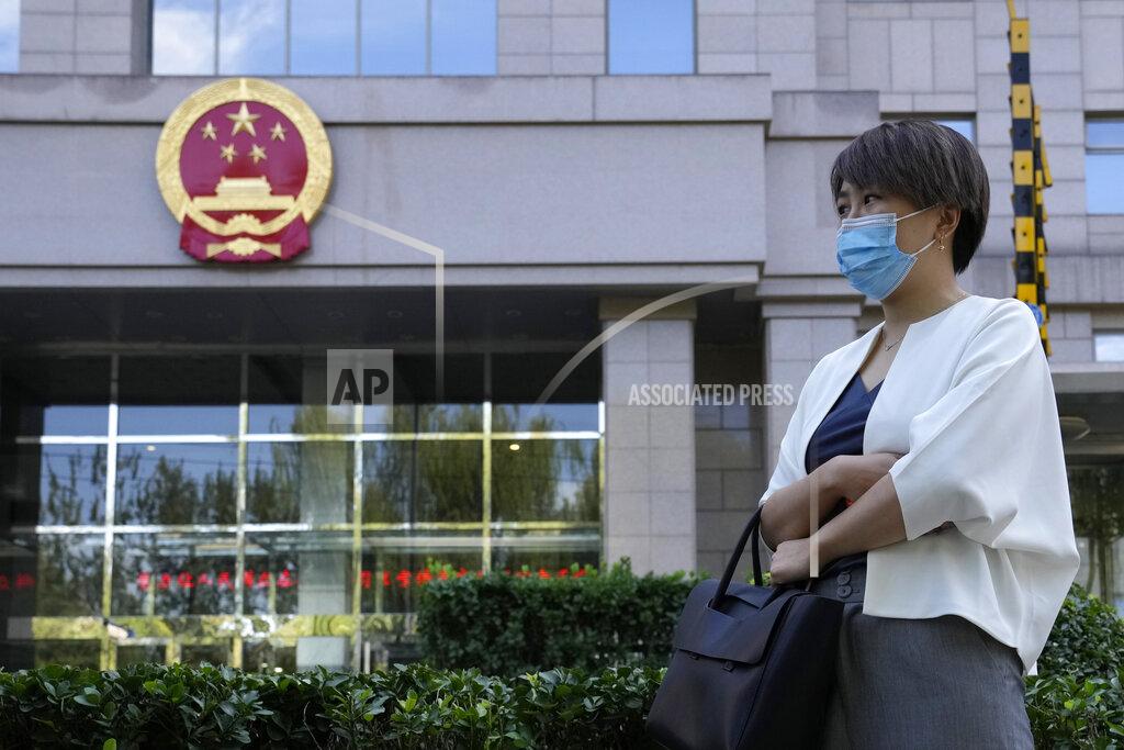 Ng Han Guan Teresa Xu prepares to attend a court session at the Chaoyang People's Court in Beijing, China, Friday, Sept. 17, 2021. After almost two years, the unmarried woman suing for the right to freeze her eggs in Beijing is getting her case heard in court Friday in a rare legal challenge against the country's restrictions on unmarried women in reproductive health. (AP Photo/Ng Han Guan)