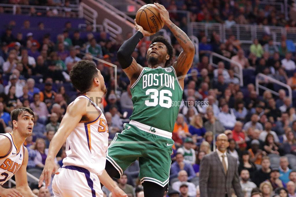 Boston Celtics guard Marcus Smart (36) shoots over Phoenix Suns guard Devin Booker during the first half of an NBA basketball game, Monday, Nov. 18, 2019, in Phoenix. (AP Photo/Matt York)