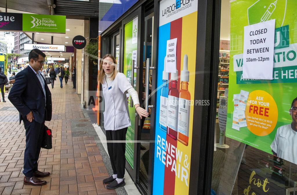 Mark Mitchell A staff member stands outside a pharmacy that closed for two hours in central Wellington, New Zealand, Wednesday, June, 23, 2021. After enjoying nearly four months without any community transmission of the coronavirus, New Zealanders were on edge Wednesday after health authorities said an infectious traveler from Australia had visited over the weekend. (Mark Mitchell/NZ Herald via AP)