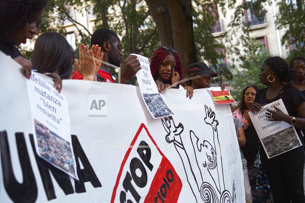 Alvaro Barrientos A woman cries while taking part in one of many protests across Spain amid for the investigation over the deaths of at least 23 people at the border between the Spanish enclave of Melilla and Morocco, in Pamplona, northern Spain, Friday, July 1, 2022. (AP Photo/Alvaro Barrientos)