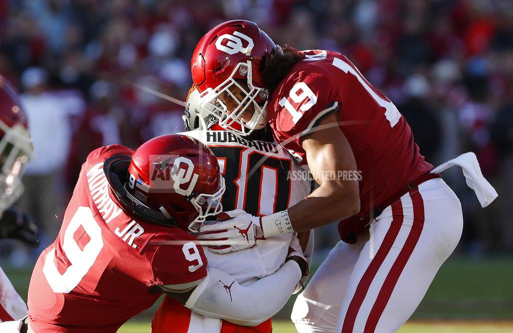Alonzo Adams Oklahoma State running back Chuba Hubbard (30) is tackled by Oklahoma linebacker Kenneth Murray (9) and linebacker Caleb Kelly (19) in the first quarter of an NCAA college football game in Norman, Okla., Saturday, Nov. 10, 2018. (AP Photo/Alonzo Adams)
